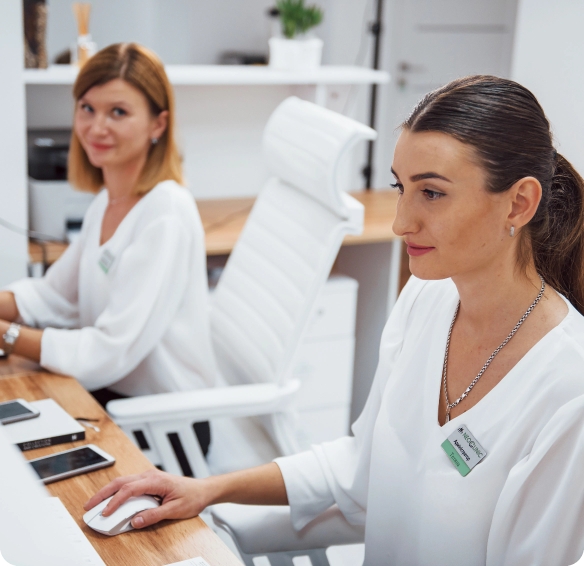 dos-enfermeras-en-uniforme-blanco-se-sientan-en-la-recepcion-del-centro estetico-haciendo-su-trabajo concetradas-luxora